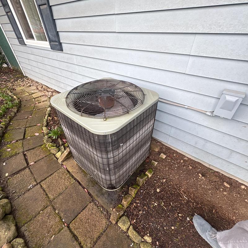 Outdoor heat pump unit installed beside home wall Outdoor heat pump unit installed beside home wall