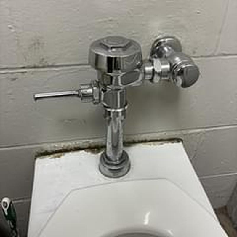 Flushometer valve on commercial toilet tank