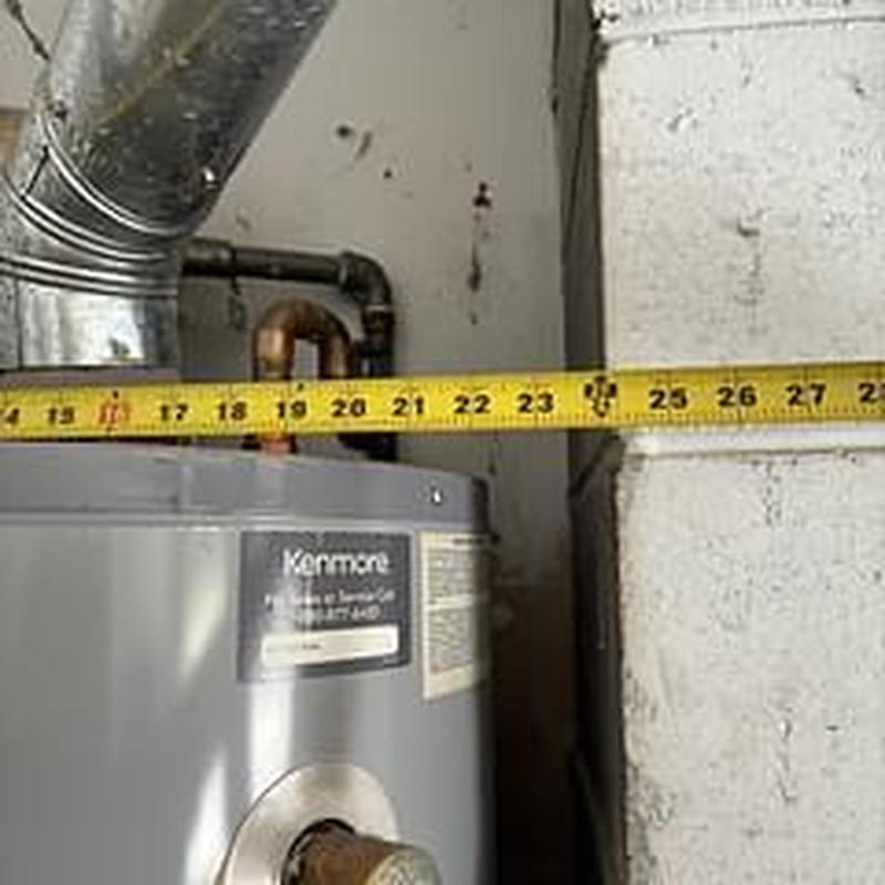 Gas water heater with measuring tape during inspection