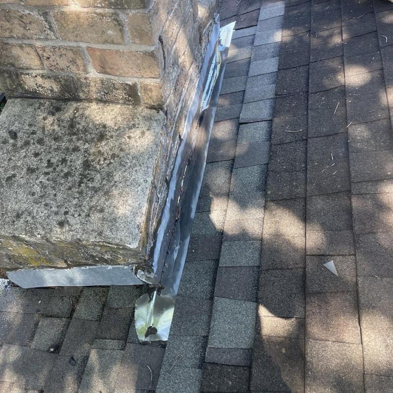 Chimney flashing installed on shingled roof edge