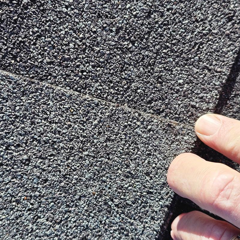 Asphalt shingle surface showing hail damage close-up