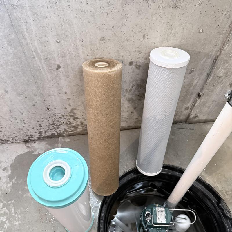 Sump pump filter cartridges next to sump basin