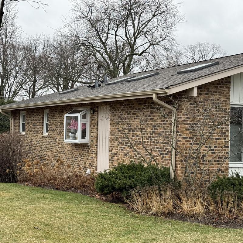 Gutter and downspout system on brick house exterior