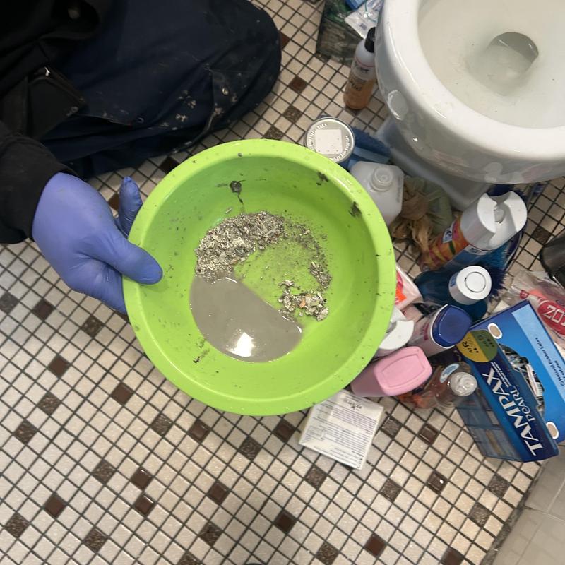 Bathroom sink line snaking debris in green bowl Bathroom sink line snaking debris in green bowl
