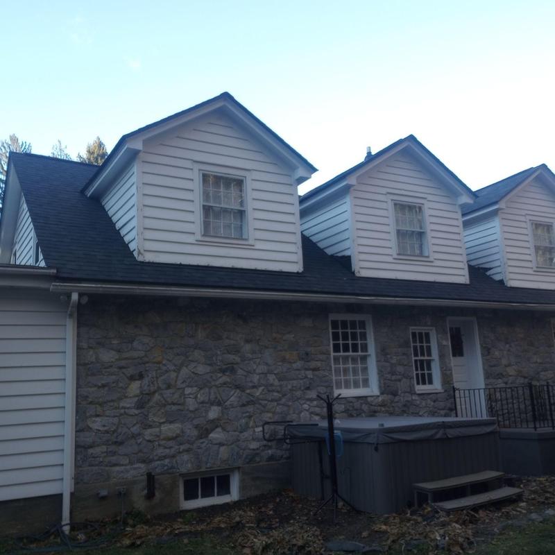 Roof shingles and wooden decking on stone and siding home