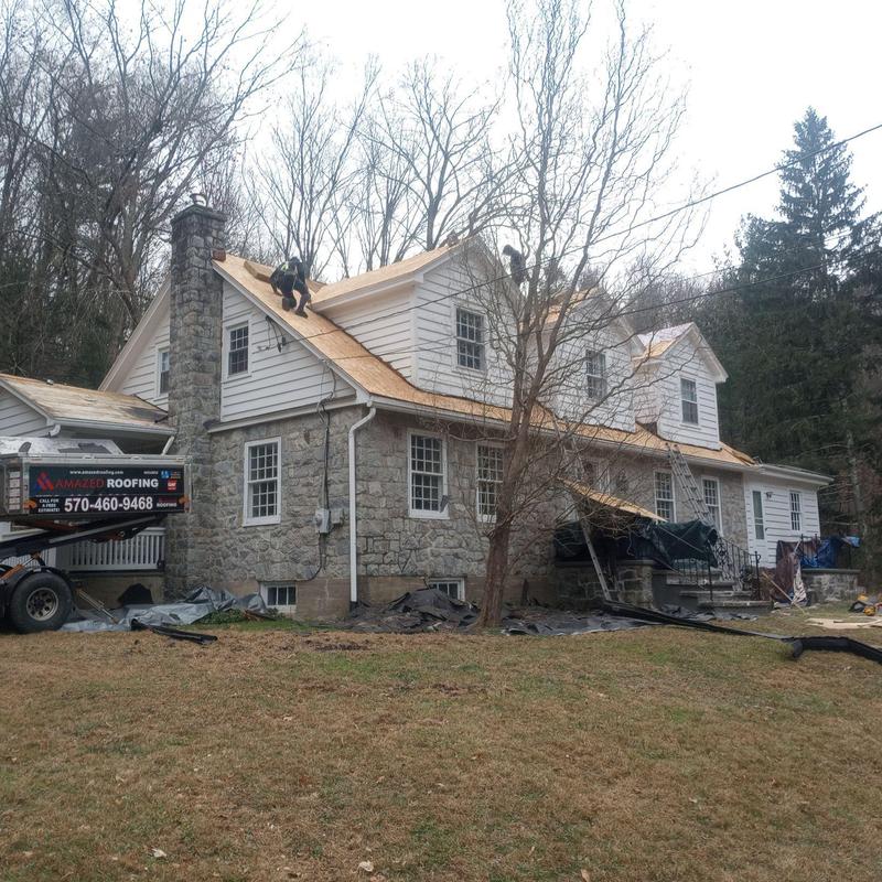 Wooden roof decking installation on stone and siding home