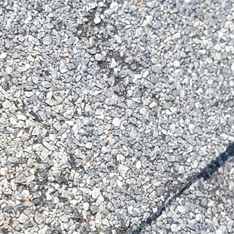 Roof shingle surface with hail storm damage cracks