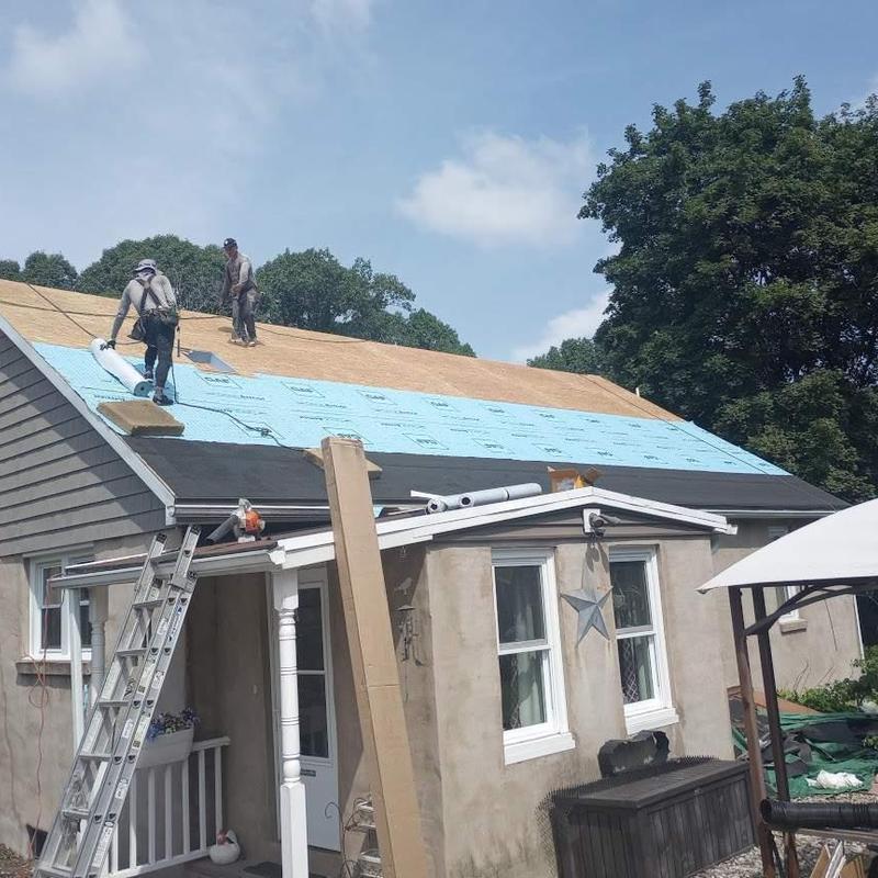 Blue roofing underlayment installation on house roof