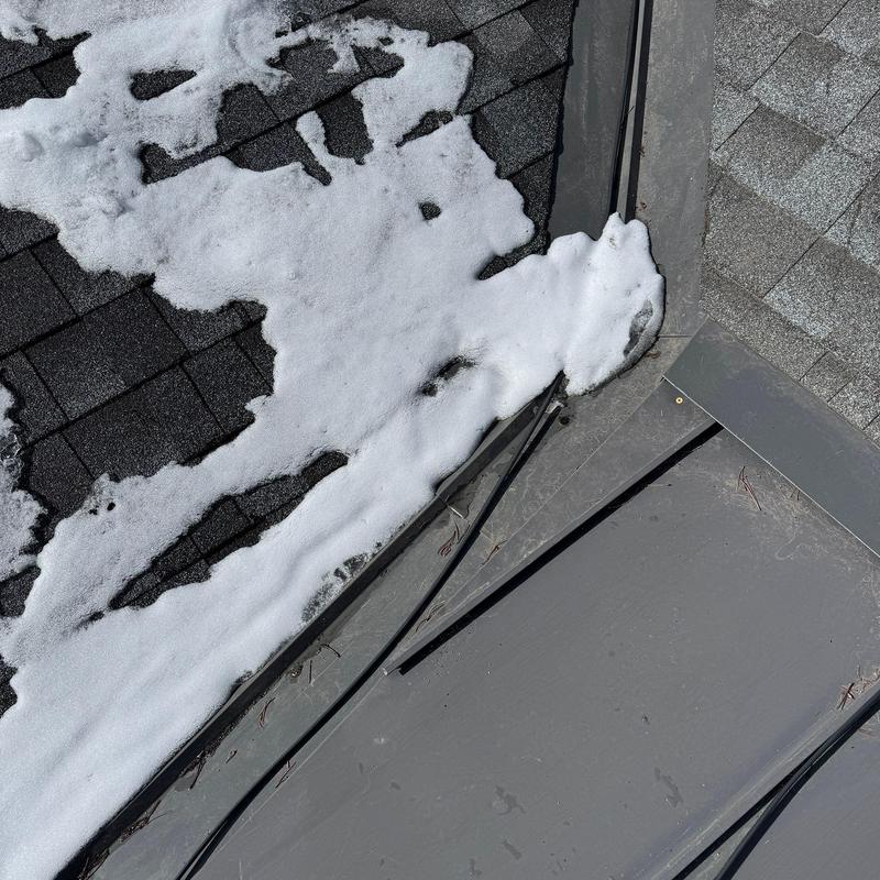 Metal roof corner with snow and asphalt shingles Metal roof corner with snow and asphalt shingles