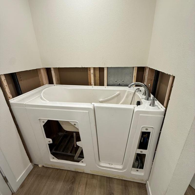 Walk-in tub installation with exposed plumbing studs