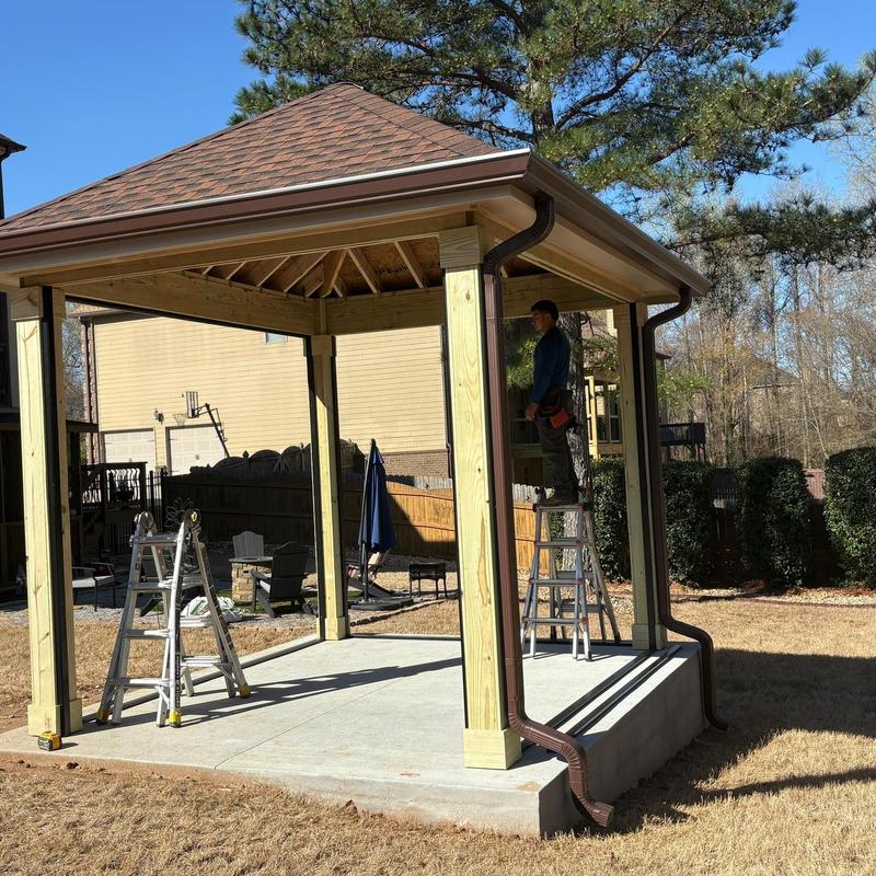 Gazebo gutter installation with downspouts and ladder