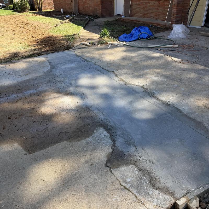 Concrete driveway patch with tools and materials nearby