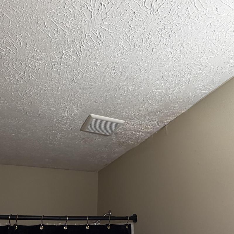 Bathroom ceiling with water damage and vent fan