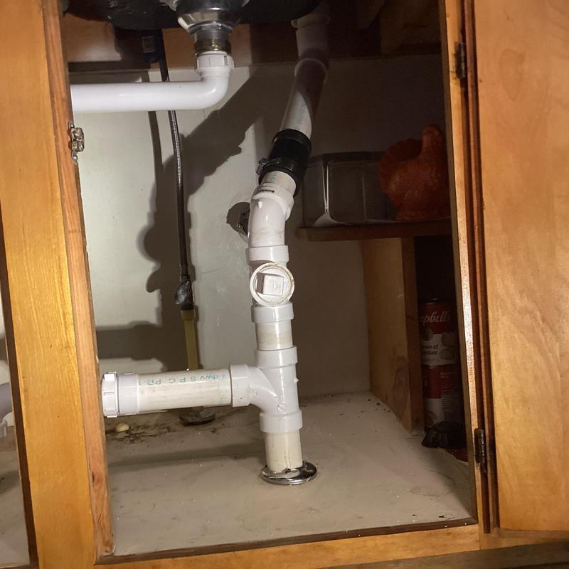 Laundry room sink drain plumbing and vent pipe under cabinet