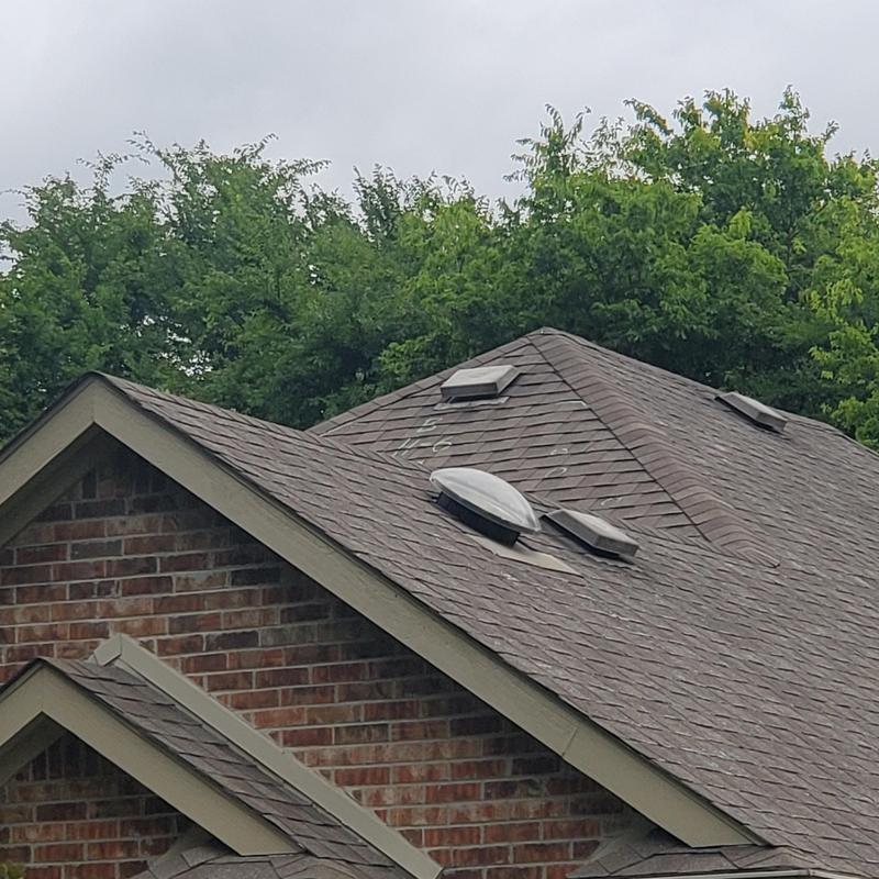 Asphalt shingle roof with hail damage marks and vents