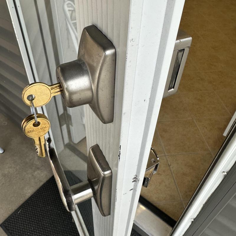 Deadbolt lock with keys on white door installation