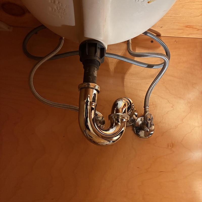 Chrome P-trap and flexible hose plumbing under sink