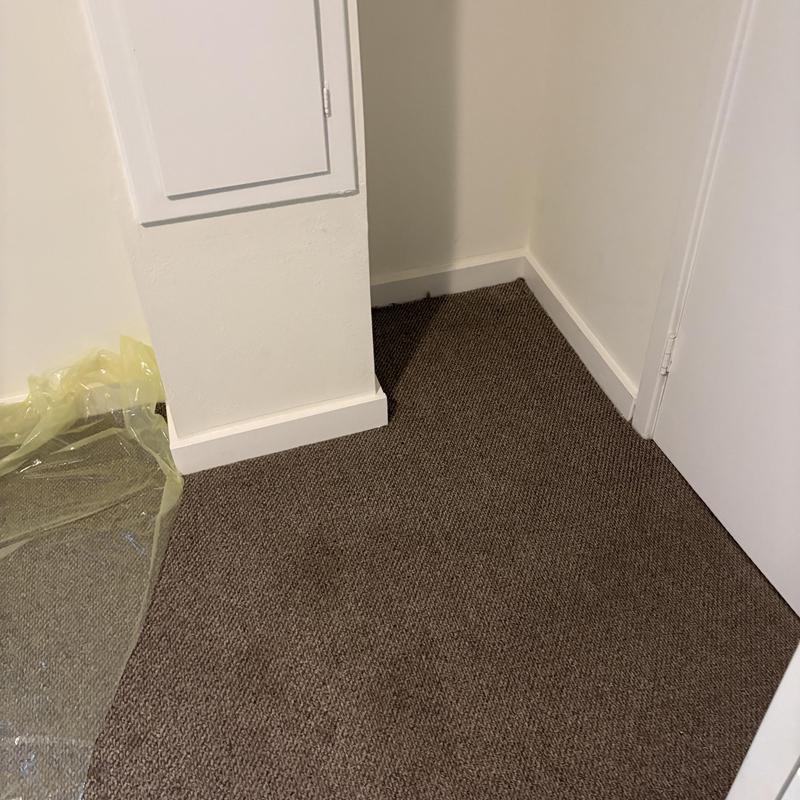 Carpet installation in room corner near white door