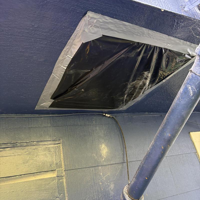 Tub overflow access patched with plastic and tape