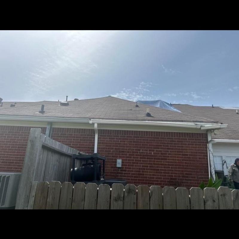 Asphalt shingle roof with storm damage and tarp cover
