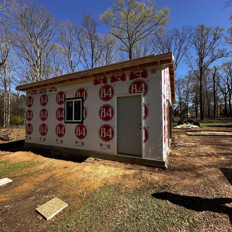 Wall panel installation on new construction shop exterior