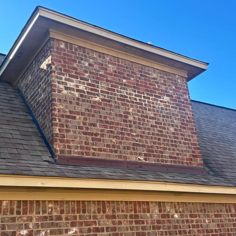 Roof chimney flashing and shingle inspection on brick home