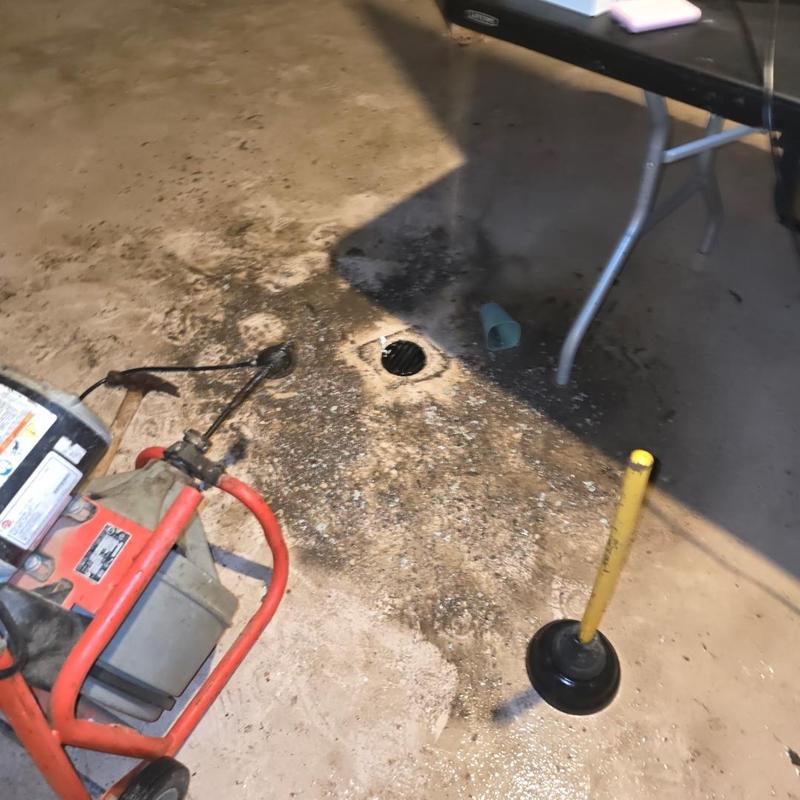 Main floor drain with plumbing snake and plunger