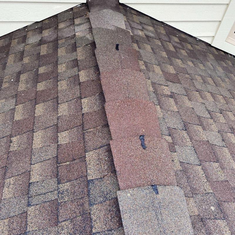 Asphalt shingle roof ridge with tabs and sealant marks