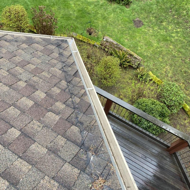 Roof shingles and gutter inspection from rooftop view