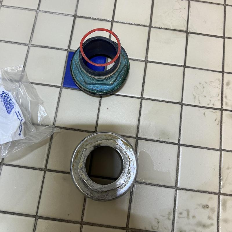 Toilet spud coupling with gasket on tiled floor