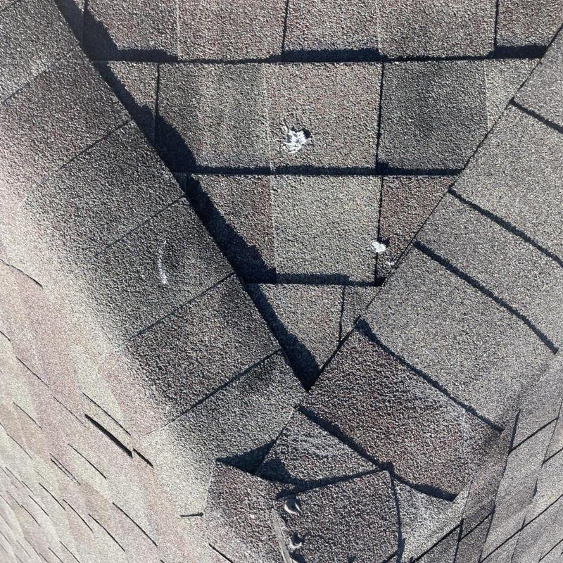 Asphalt shingles with nail pops and damage on roof