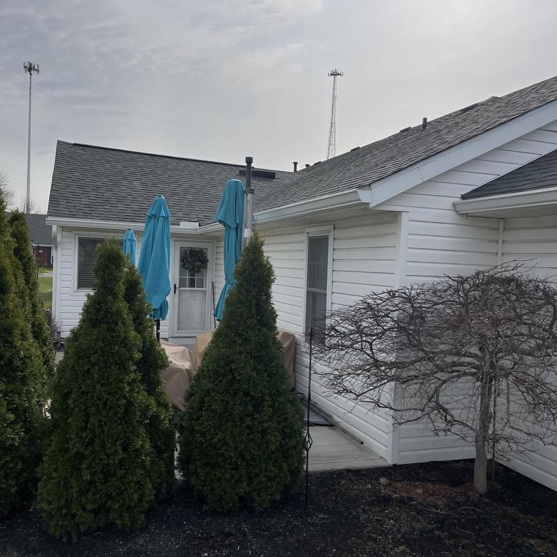 Asphalt shingle roof with white siding and patio umbrellas Asphalt shingle roof with white siding and patio umbrellas