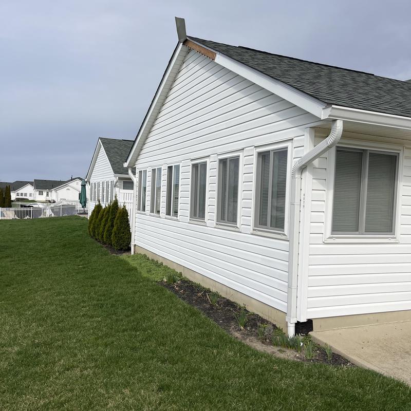 Fascia board on white house exterior with gutter downspout Fascia board on white house exterior with gutter downspout