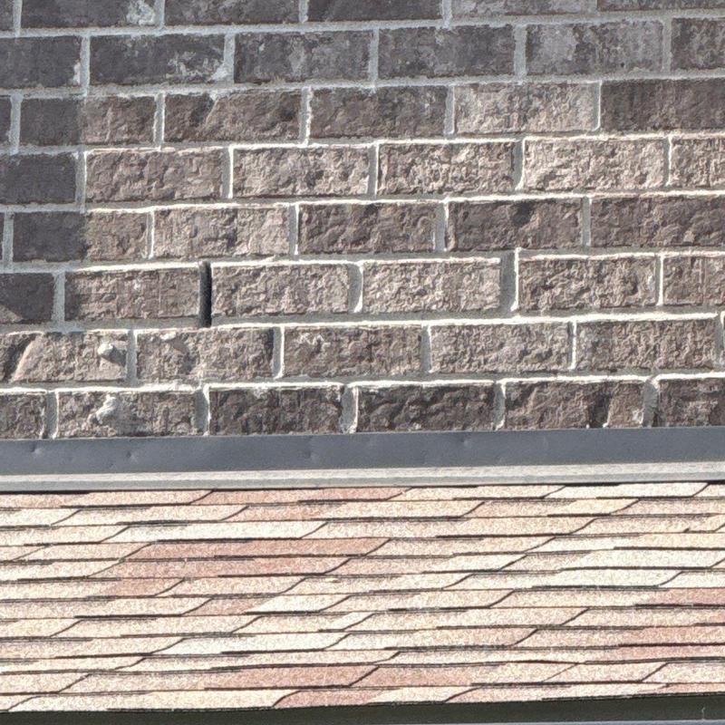 Roof shingles and brick wall hail damage inspection