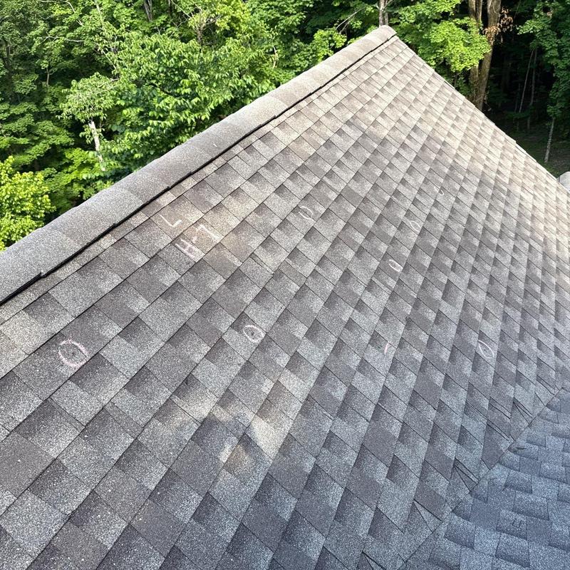 Asphalt shingles with hail damage marked in chalk
