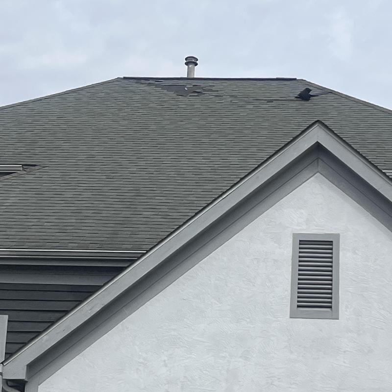 Roof shingles with damage and missing sections Roof shingles with damage and missing sections
