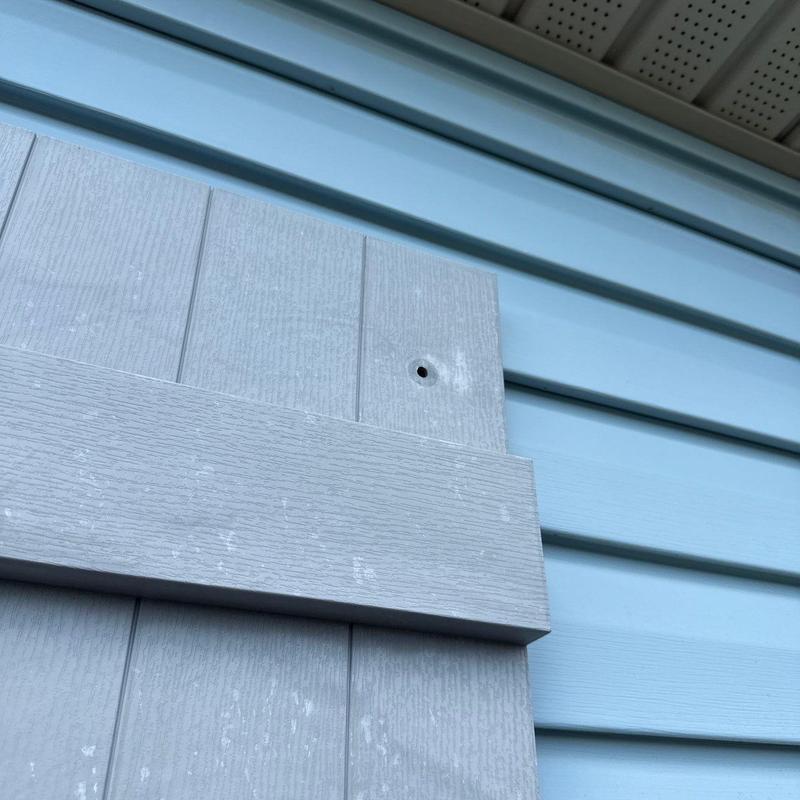 Siding panel with missing screw and hole damage