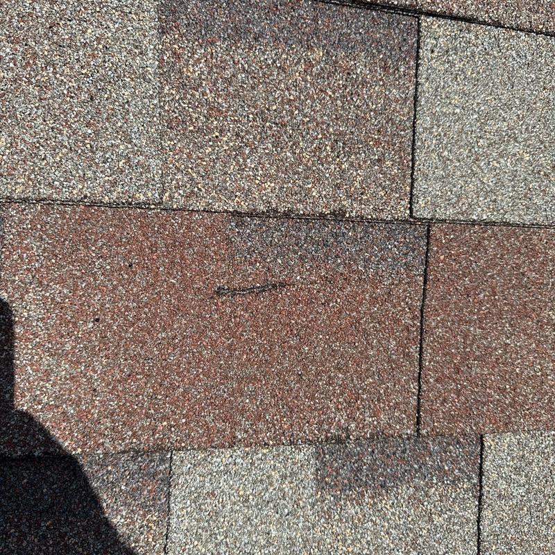 Roofing shingles with visible hail impact damage