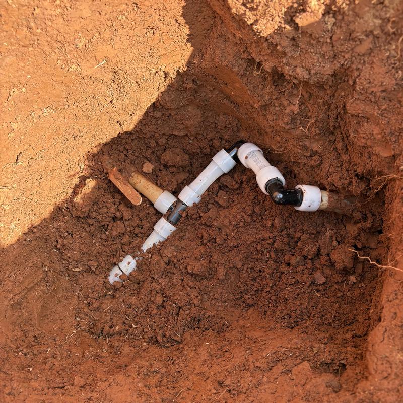 Water service line with PVC fittings in dirt trench