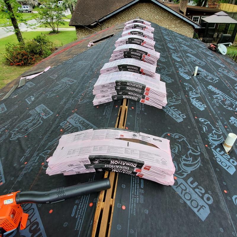 Owens Corning Brownwood shingles stacked on roof underlayment