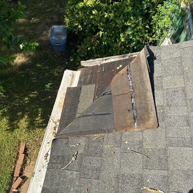 Asphalt shingle roof with lifted damaged shingles
