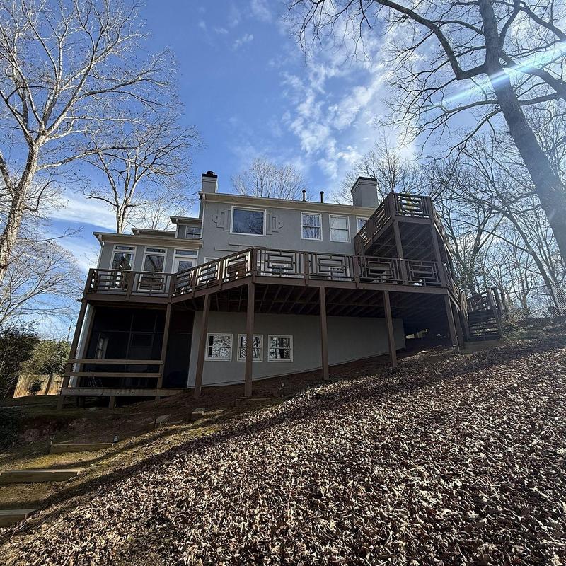 Deck structure with roof overhead on sloped yard