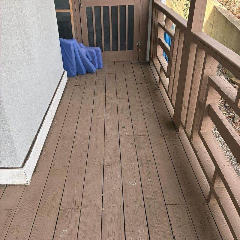 Wooden deck flooring with railing and folded cushions