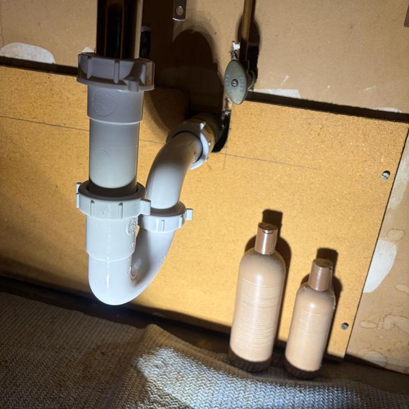 P-trap plumbing under bathroom vanity with water valve