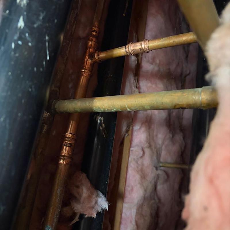 Copper waterlines behind vanity with insulation