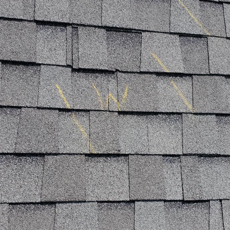 Asphalt shingle roof with marked hail damage spots