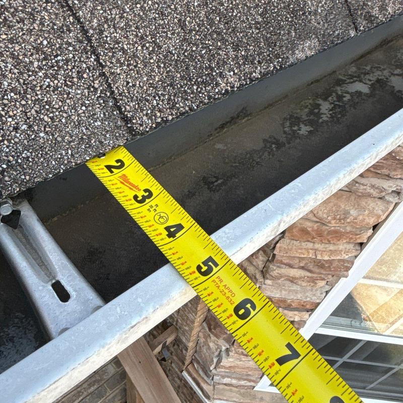 Roof gutter with measuring tape showing length