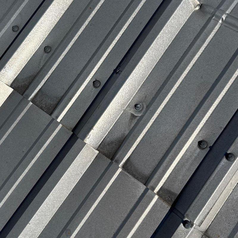 Metal roofing panels with hail damage and fasteners
