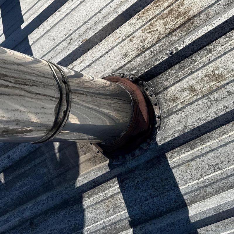 Metal roof flashing around vent pipe with rust and damage