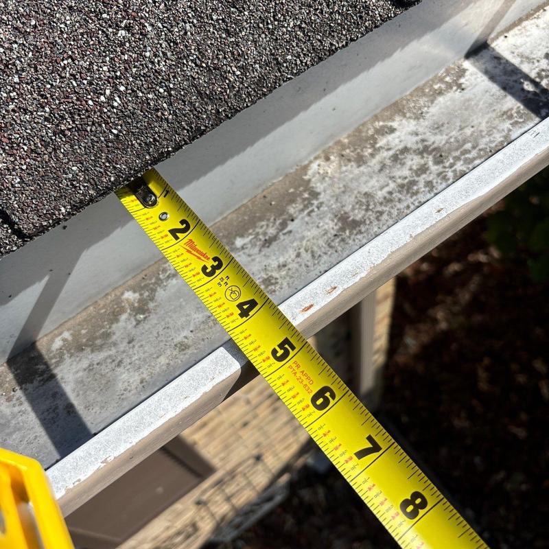 Roof gutter measured with tape during inspection
